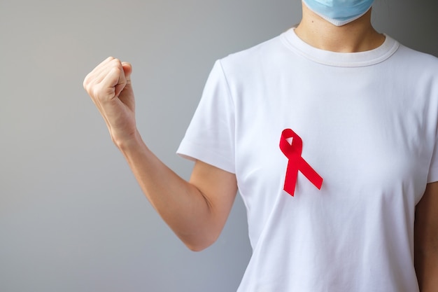 Rotes Band für den Welt-Aids-Tag im Dezember (erworbenes Immunschwächesyndrom), den Monat des Bewusstseins für multiples Myelom gegen Krebs und die Nationale Rote Schleife-Woche. Konzept des Gesundheitswesens und des Weltkrebstages