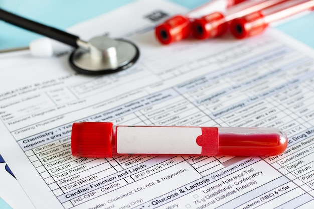 Foto rotes blutfläschchen mit blutprobe über dem hintergrund des testformulars