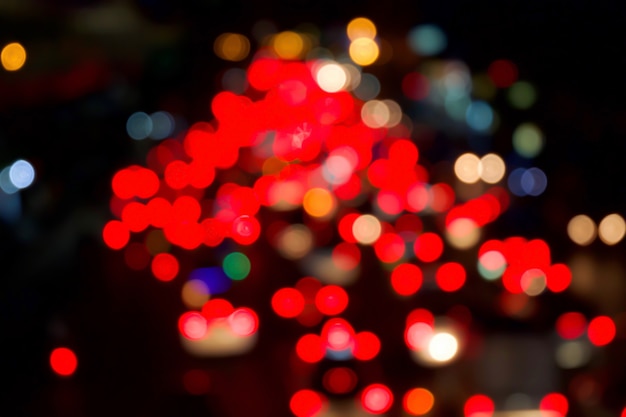 Rotes bokeh licht vom auto auf straße in der stadt in der nacht. unscharf gestellt von nachtverkehr.