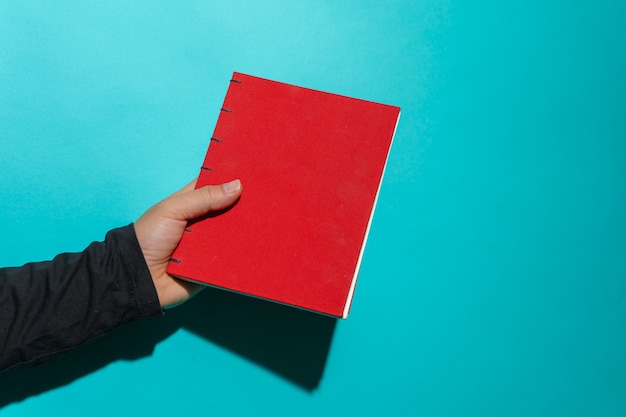 Rotes Buch isoliert schwebend sauber vor blauem Hintergrund mit Kopienraum für Text