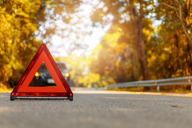 Rotes Dreieck, rotes Not-Aus-Schild, rotes Not-Symbol und schwarzes Auto halten an und parken auf der Straße.