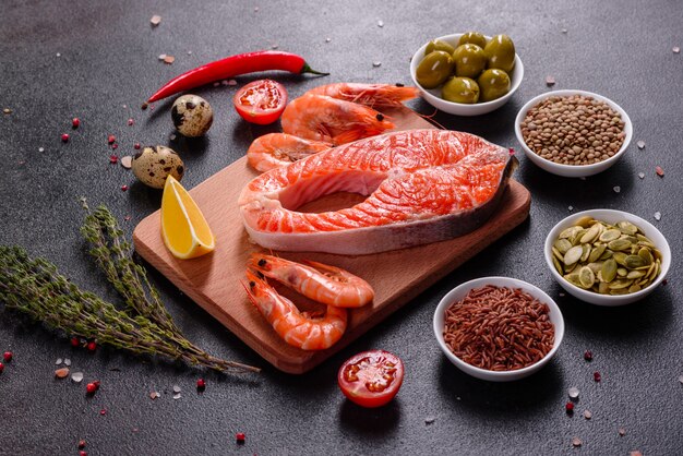 Rotes Fischsteak der rohen Forelle diente mit Kräutern und Zitrone und Olivenöl. Lachs kochen. Gesundes Essenkonzept