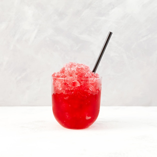 Rotes Fruchteisgetränk Granizado oder Slushie-Getränk mit natürlichem Saft. Fruchtraspeleis im Klarglas.