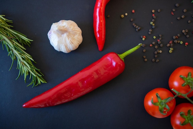 Rotes Gemüse auf schwarzem Hintergrund Paprika und Tomaten Knoblauch