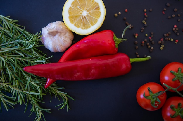 Rotes Gemüse auf schwarzem Hintergrund Paprika und Tomaten Knoblauch