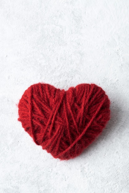 Rotes Herz von Hand aus Garn, Liebessymbol zum Valentinstag.