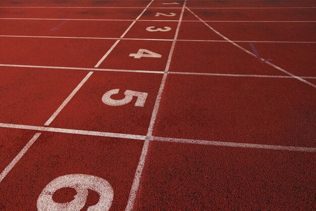 Rotes Leichtathletik-Laufband im Stadion mit der Nummerierung.