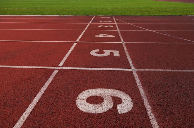 Rotes Leichtathletik-Laufband im Stadion mit der Nummerierung.