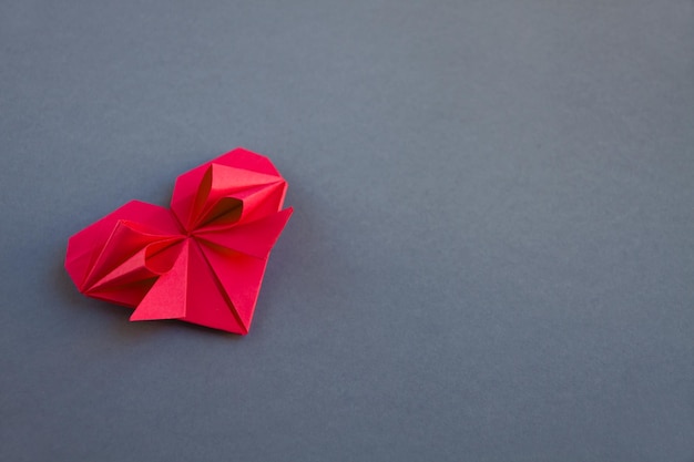 Rotes Papierherz Origami isoliert auf grauem Hintergrund