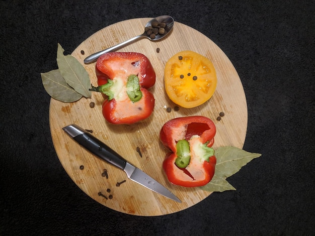 Rotes Perer und gelbes Tomatenmesser und Löffel auf dem Schreibtisch Draufsicht flach gelegt