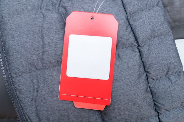 Foto rotes preisschild auf grauer winterjacke mit platz für ihren text.