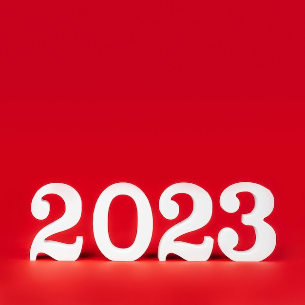 Rotes quadratisches Banner mit weißen Holzzahlen 2023 steht unten Frohe Weihnachten Kopierbereich Platz für Text