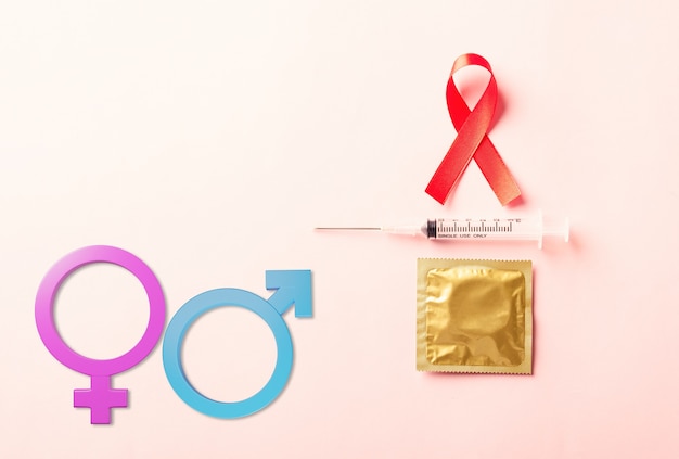 Rotes Schleifenbandsymbol HIV-AIDS-Krebsbewusstseinskondom und -spritze mit männlichen weiblichen Geschlechtszeichen