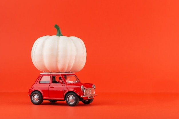 Rotes Spielzeugauto mit einem Kürbis lokalisiert