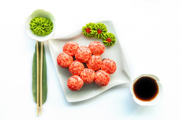 Rotes sushi auf weißem teller und weißer oberfläche mit wasabi und essstäbchen