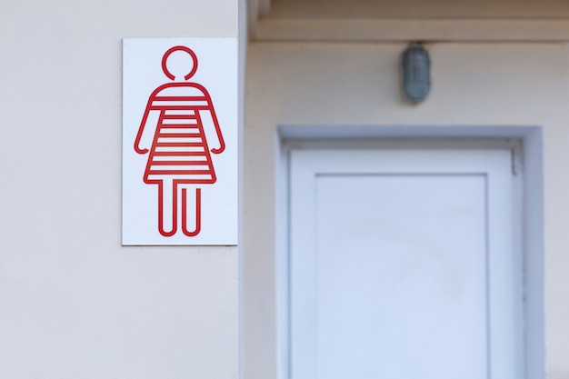 Foto rotes symbol einer person, die eine weibliche toilette auf der straße bezeichnet. vorderansicht.