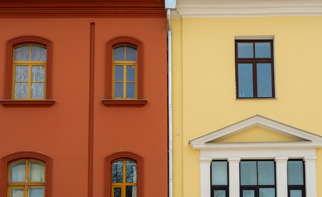 Rotes und gelbes gebäude mit fenstern nebeneinander geometrische zusammensetzung von zwei gebäuden