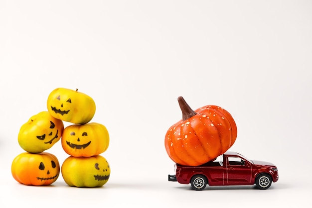 Rotes Vintage-Spielzeugauto mit kleinen Halloween-Kürbissen auf dem Dach