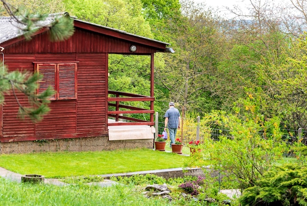 Rotes Wochenendhaus aus Holz mit Garten im Frühling
