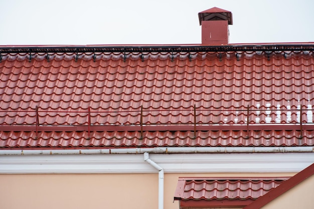 Rotes Ziegeldach auf einem neuen Gebäude nach Renovierungsnahaufnahme Reparatur des Daches Sanierung heruntergekommener Wohnungen Isolierung der Fassade des Hauses