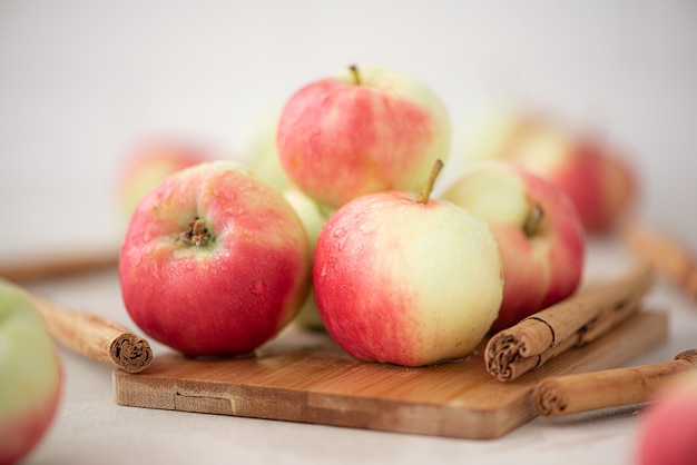 Rotgelbe kleine Äpfel mit Zimtstangen