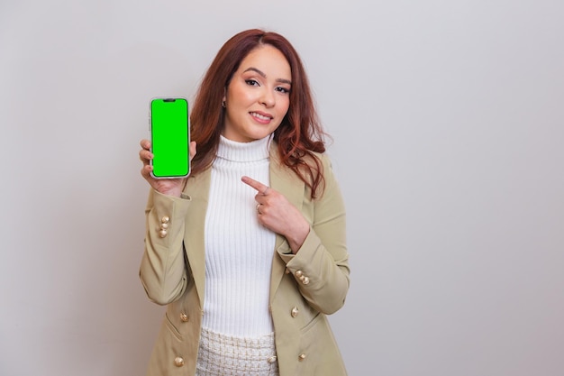 Rothaarige Brasilianerin, Kosmetikerin, Schönheitsprofi, präsentiert Mobiltelefon mit Chroma-Bildschirm