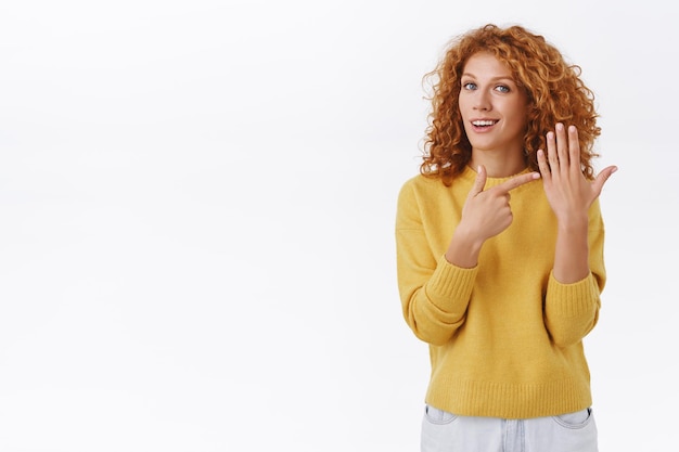 Foto rothaarige frau, die auf den finger zeigt und lächelt, will braut werden