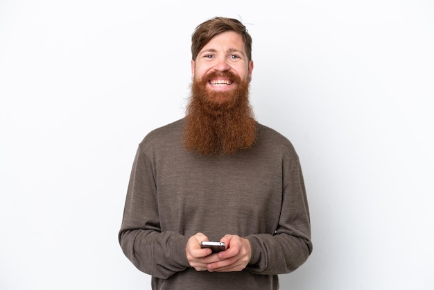 Rothaariger Mann mit Bart isoliert auf weißem Hintergrund, der eine Nachricht mit dem Handy sendet