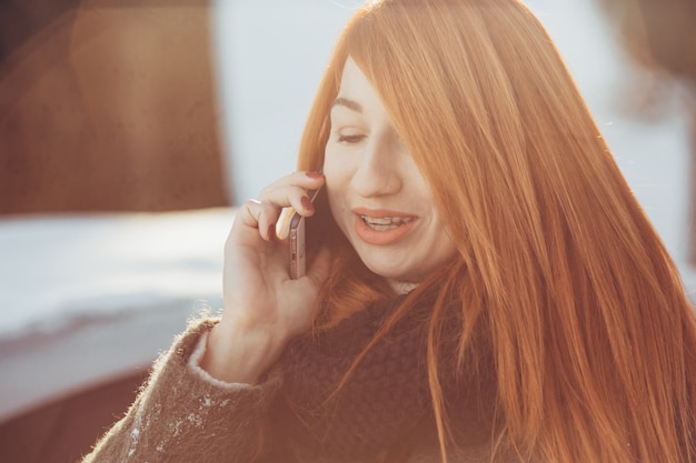 rothaariges Mädchen am Telefon sprechen