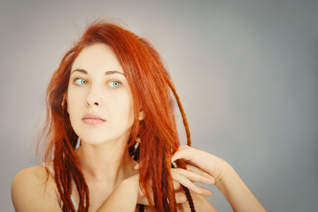 Foto rothaariges mädchen kämmt ihre dreadlocks mit fingern boho oder hippie-frisur frau mit zöpfen von k...