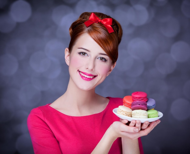 Rothaariges Mädchen mit Macaron zum Valentinstag.