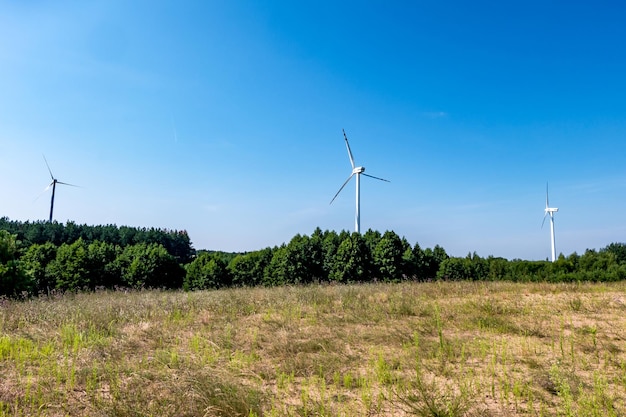 Rotierende Blätter einer Windmühle Propeller auf blauem Himmelshintergrund Erzeugung von Windenergie Reine grüne Energie