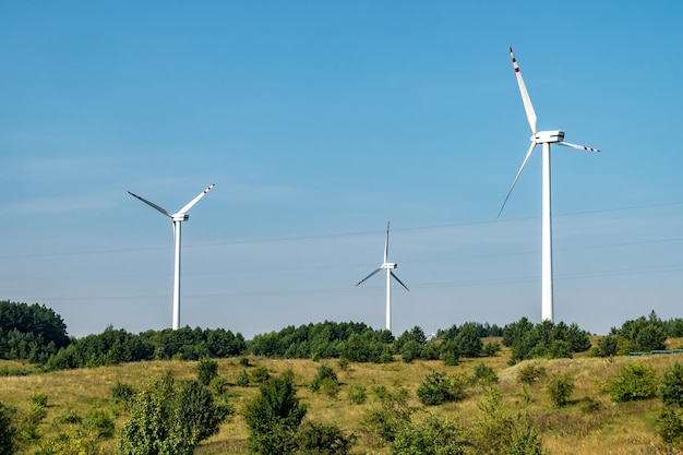 Rotierende Blätter einer Windmühle Propeller auf blauem Himmelshintergrund Erzeugung von Windenergie Reine grüne Energie