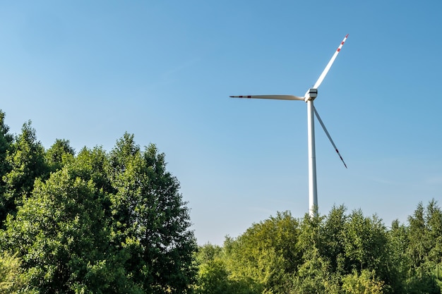 Rotierende Blätter einer Windmühle Propeller auf blauem Himmelshintergrund Erzeugung von Windenergie Reine grüne Energie