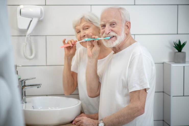Foto rotina matinal. casal de idosos escovando os dentes e parecendo satisfeito