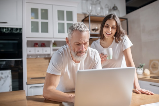 Rotina matinal. Um casal checando e-mails matinais enquanto toma um café