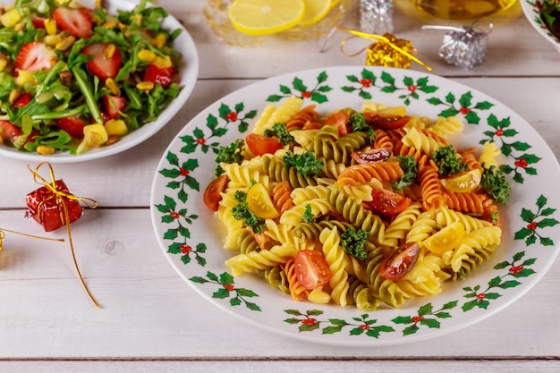 Rotini-Nudeln mit grünem Salat auf Weihnachtstisch