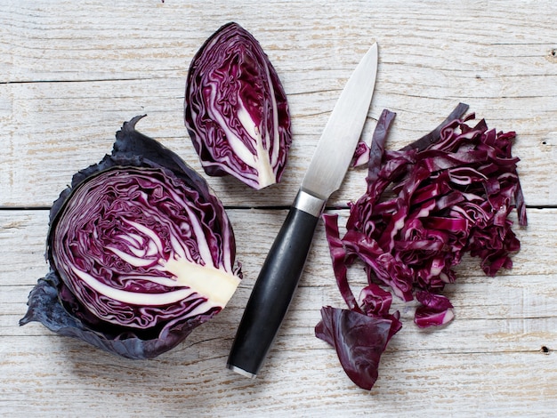 Foto rotkohl mit einem messer auf einer hölzernen tischoberansicht