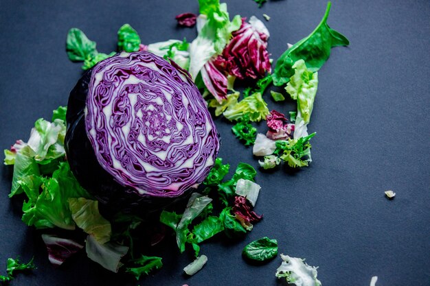 Rotkohl und andere Salate auf dunkler Oberfläche. Ansicht von oben