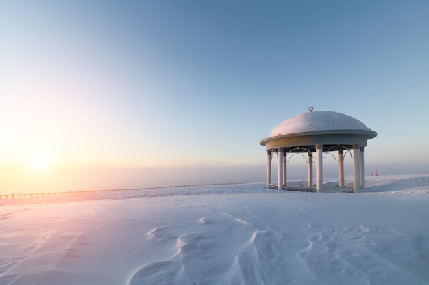 Rotonda en una llanura nevada. Amanecer de invierno.