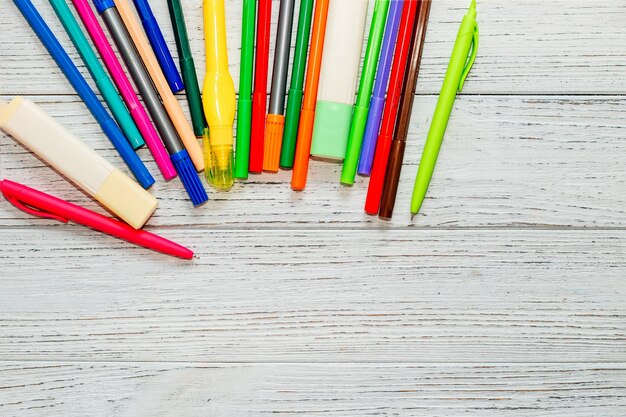 Rotuladores de colores de papelería sobre una mesa blanca