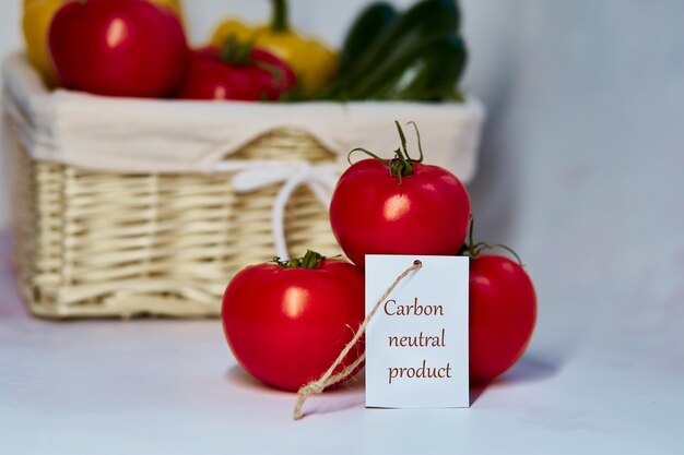 Rótulo de produto neutro em carbono nos tomates Rotulagem de carbono Cesto de vegetais no fundo Livre de emissões líquidas de carbono zero Produtos agrícolas orgânicos do mercado local