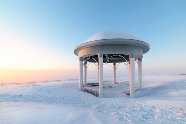 Rotunde auf einer schneebedeckten Ebene. Winterdämmerung.