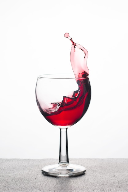 Rotwein in einem Glas mit Spritzern