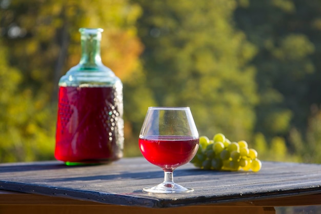 Rotwein in einem Glas und einer Flasche Unscharfer Hintergrund