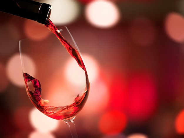 Rotwein in Glas auf den Hintergrund gießen