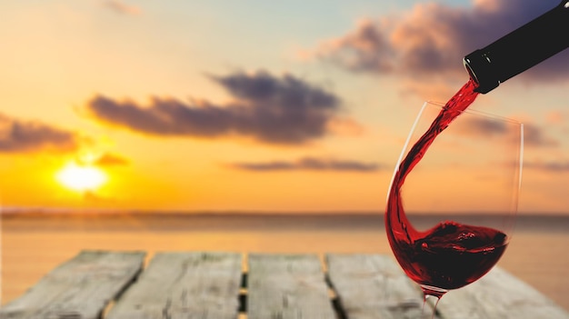 Rotwein in Glas auf hellem Hintergrund gießen