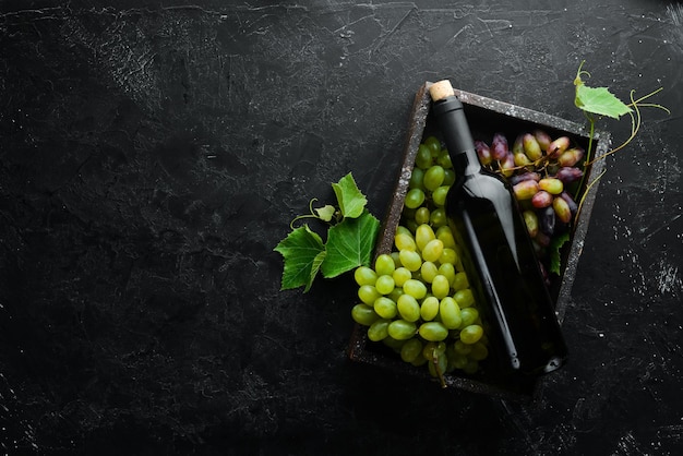 Rotwein und frische trauben auf einem schwarzen steintisch draufsicht freier platz für ihren text