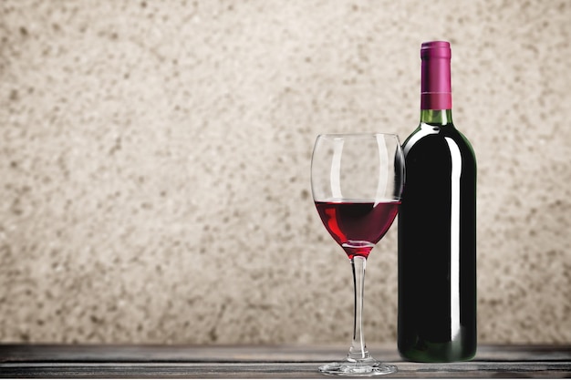 Rotwein und Glas auf Holztisch