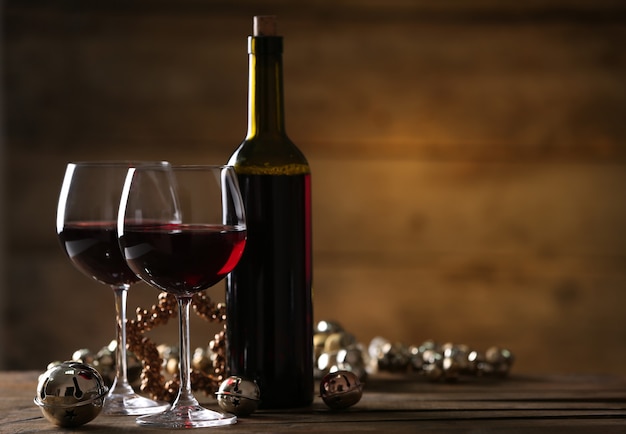 Rotwein und weihnachtsschmuck auf holztisch auf holzoberfläche